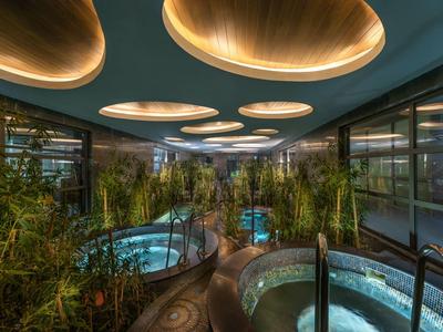 Modernes Spa mit mehreren Whirlpools und atmosphärischer Beleuchtung.