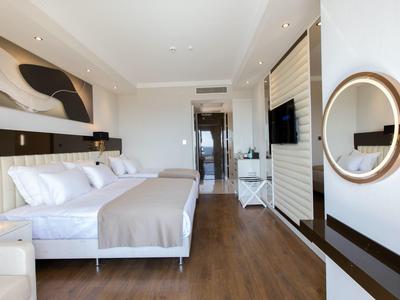 Habitación de hotel iluminada con cama doble, suelo de madera y diseño moderno.