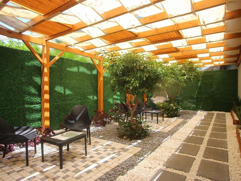 Covered terrace with seating and well-maintained paving in a garden area.