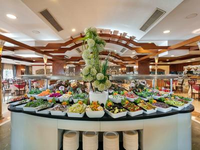 Buffet in elegantem Restaurant mit vielfältigem kaltem und warmem Essen, zentraler Blumendeko.