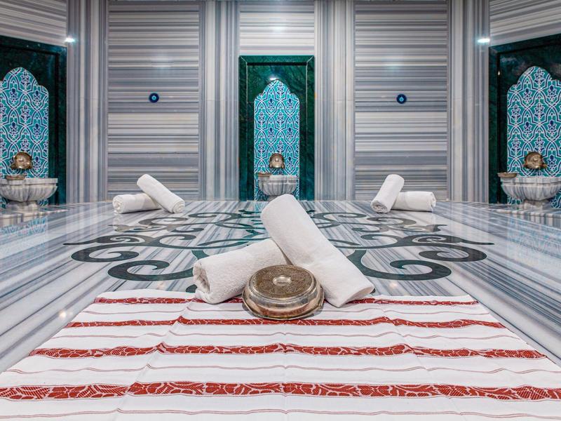 Luxusní turecký hammam s mramorem, ručníky a tradičními miskami.
