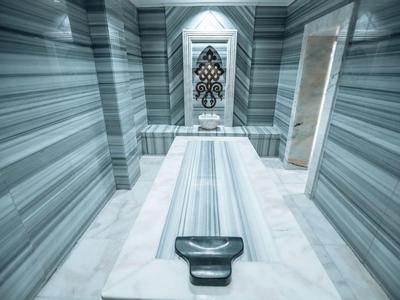 Elegante hammam con muri in marmo e blocco massaggi centrale in un hotel di lusso.