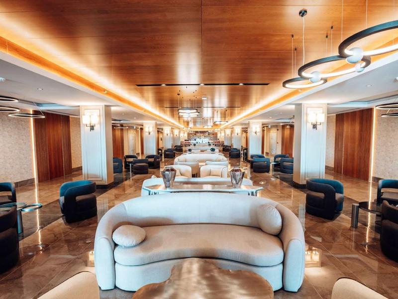 Salon d’hôtel moderne et luxueux avec canapés confortables et décor en bois chaleureux.