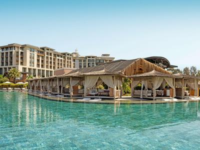 Luxuriöses Resort mit großem Pool und Pavillons unter blauem Himmel.