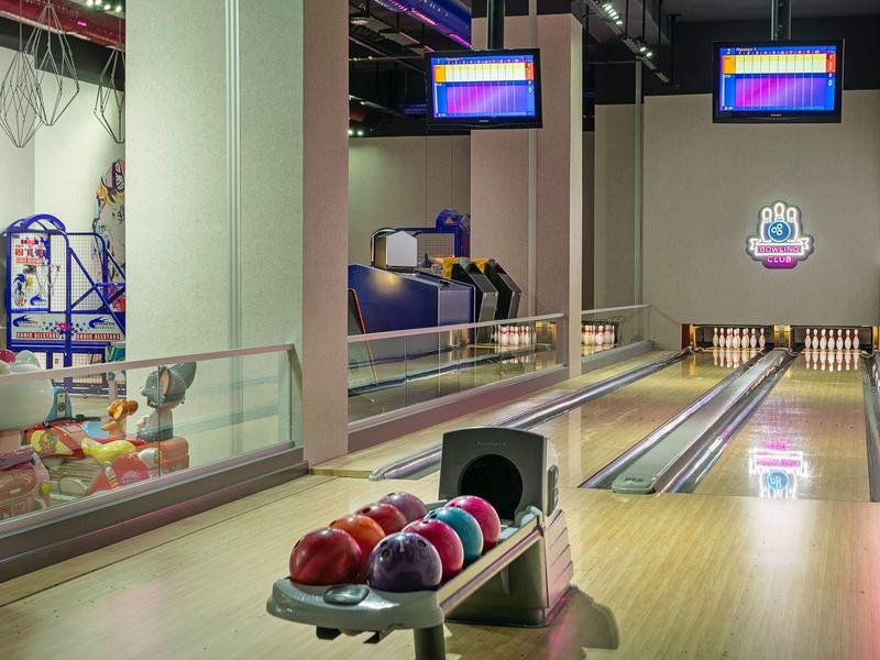 Centro de bolos moderno con pistas bien iluminadas, bolas de colores y pantallas digitales.