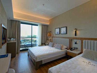 Habitación de hotel con dos camas, vista desde la ventana y mobiliario moderno.