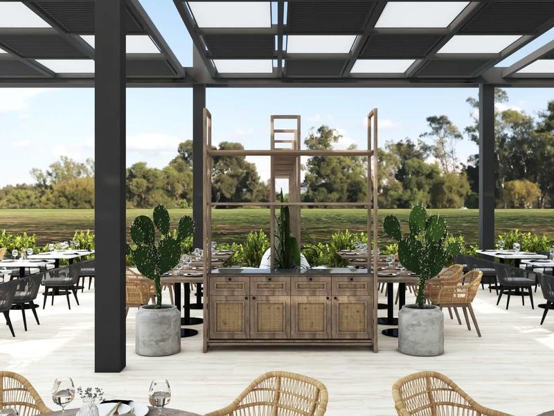 Nowoczesny zewnętrzny obszar hotelu z stołami i krzesłami pod szklanym dachem z widokiem na zielony krajobraz.