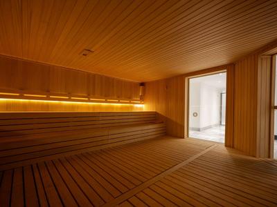 Salle de sauna en bois avec bancs intégrés et éclairage doux.