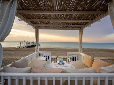 Accogliente lounge su una terrazza con vista sul mare e sulla spiaggia al tramonto.