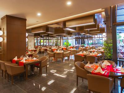 Moderní restaurace s prostřenými stoly a pohodlnými židlemi za teplého osvětlení.