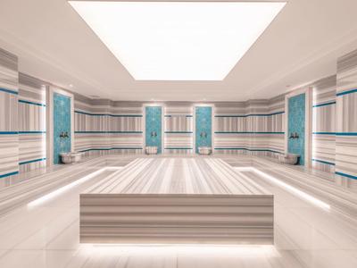 Prostorná místnost se stěnami a lavičkou s pruhy, osvětlená velkým stropním světlem.