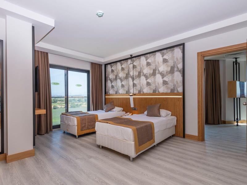 Prostorný hotelový pokoj se dvěma postelemi, moderním zařízením a výhledem ven.