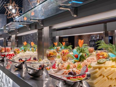Un buffet con una selección de quesos, verduras y aperitivos en un restaurante moderno de hotel.