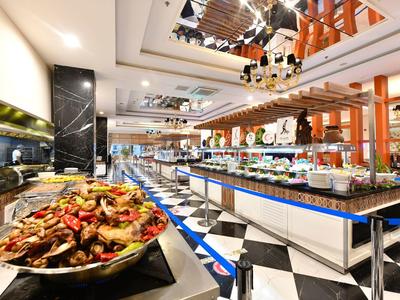 Großzügiges Buffet mit vielfältigem Essen, helle Beleuchtung und modernes Interieur in Restaurant.
