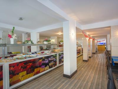 Großes Buffet mit vielfältigem Essen in hellem Raum und gemusterter Bodenfliese.