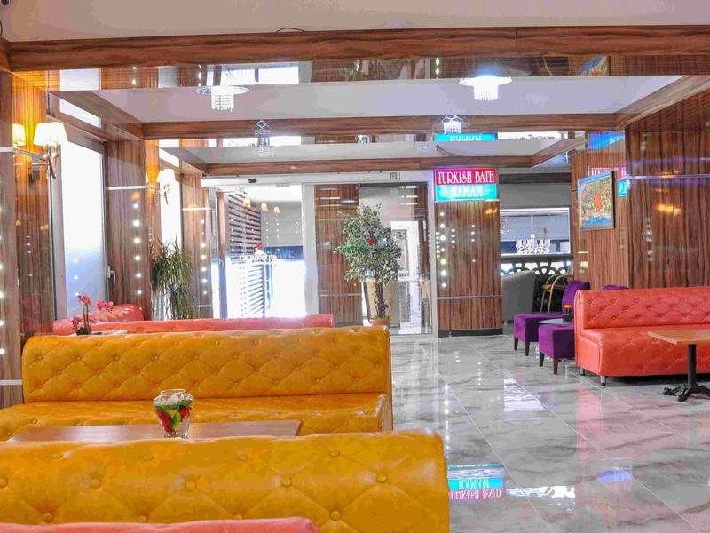 Heller, moderner Innenraum mit orangefarbenen Sitzbänken, Marmorfußboden und Holzdecke.