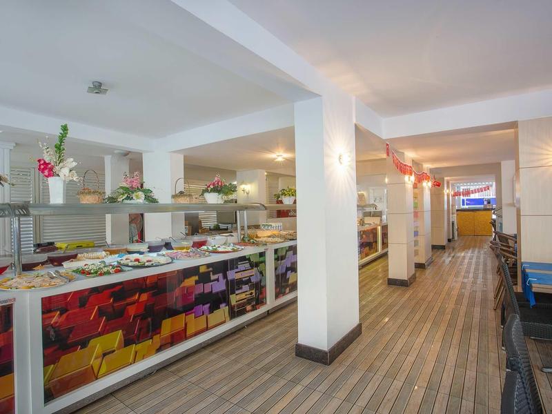 Großes Buffet mit vielfältigem Essen in hellem Raum und gemusterter Bodenfliese.