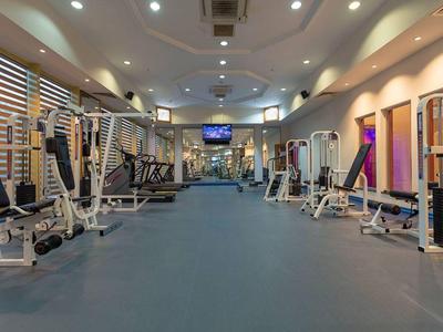 Palestra moderna con varie attrezzature per allenamento e illuminazione soffusa.