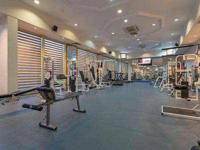 Ampia palestra con varie moderne attrezzature per allenamento e pavimento blu.