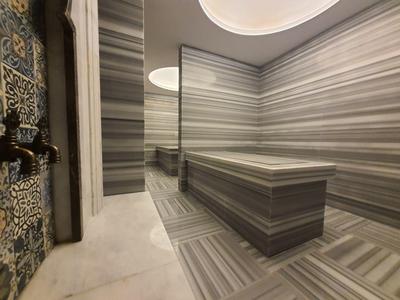 Moderne wellnessruimte met hammam en gestreepte marmeren vloeren en muren.