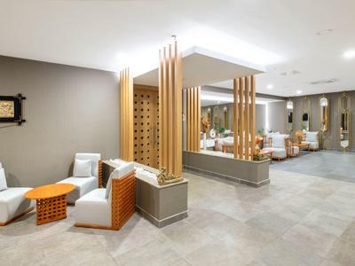 Área de salón moderna del hotel con asientos cómodos y paneles de madera.