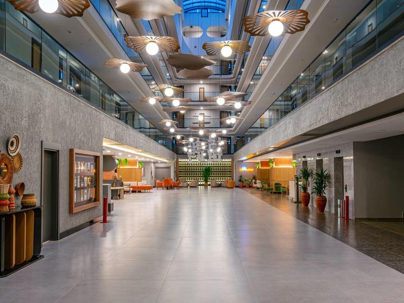 Couloir d'hôtel lumineux et moderne avec lampes et zones de sièges de chaque côté