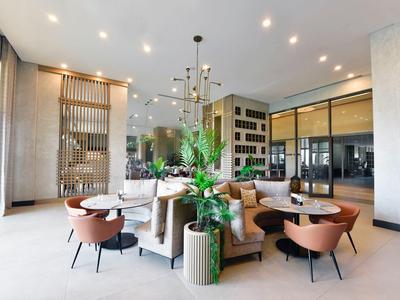 Moderní světlý hotelový salonek s pohodlným sezením a výrazným osvětlením.