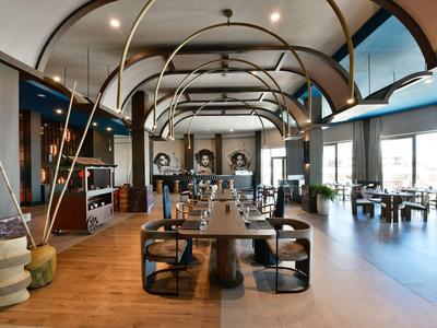 Prostorná jídelna s dřevěnými podlahami, velkými okny a moderním nábytkem.