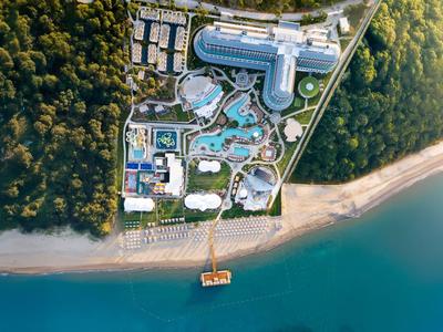 Luxusní resort s bazény a přímým přístupem na pláž, obklopen hustým lesem.