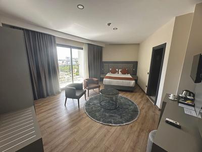 Moderně vybavený hotelový pokoj s manželskou postelí, posezením a balkonem s výhledem.