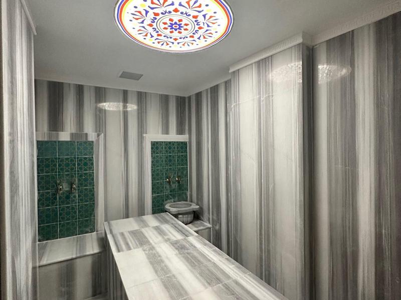 Moderní léčebna s mramorovým stolem a nepřímým stropním osvětlením.