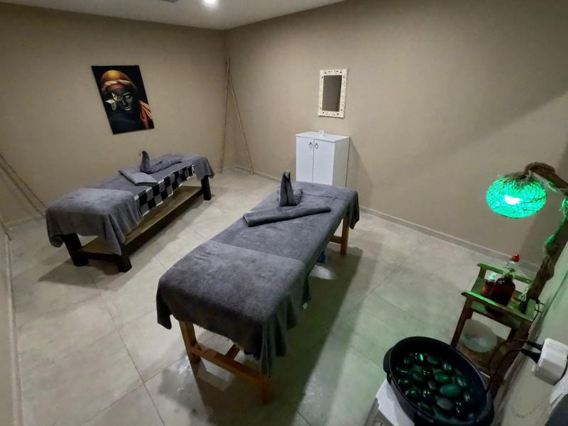 Jednoduchá léčebná místnost se dvěma masážními stoly, tlumeným osvětlením a relaxační atmosférou.