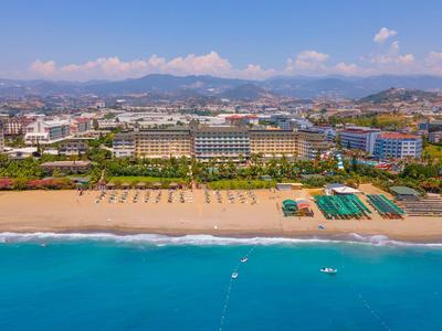 Indoor pool with glass roof, lounge chairs, and a person relaxing in the hot tub area.