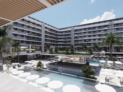 Complejo hotelero moderno con piscina exterior, muebles blancos y palmeras bajo un cielo soleado.