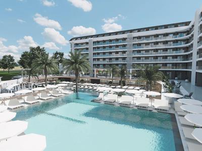 Nowoczesny hotelowy basen z leżakami i palmami pod błękitnym niebem.