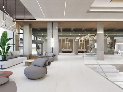 Área moderna de vestíbulo de hotel con asientos, plantas e interior brillante.