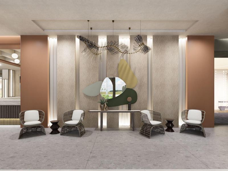 Nowoczesna przestrzeń lobby hotelowej z eleganckimi fotelami, dziełem sztuki i ciepłymi tonami.