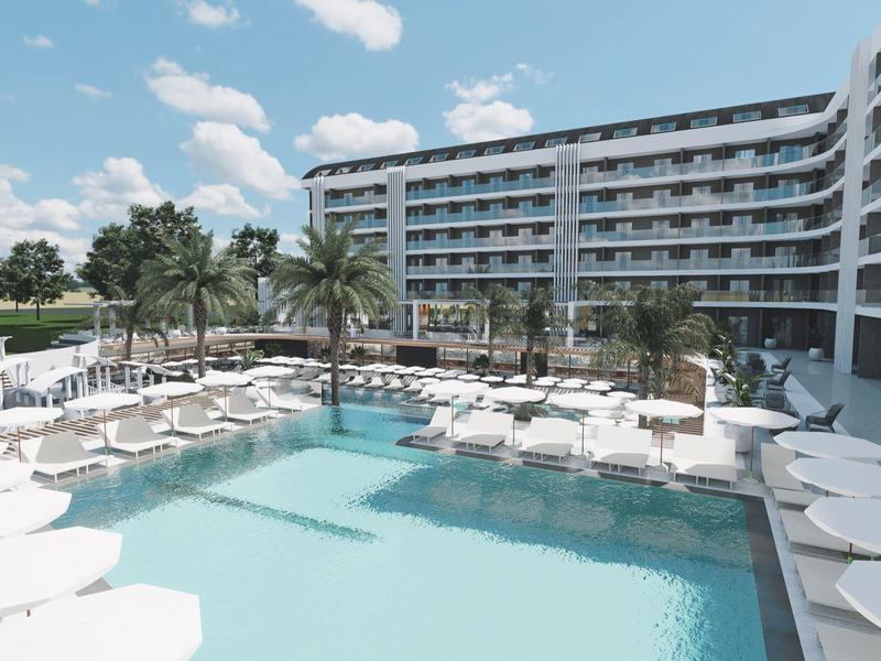 Nowoczesny hotelowy basen z leżakami i palmami pod błękitnym niebem.