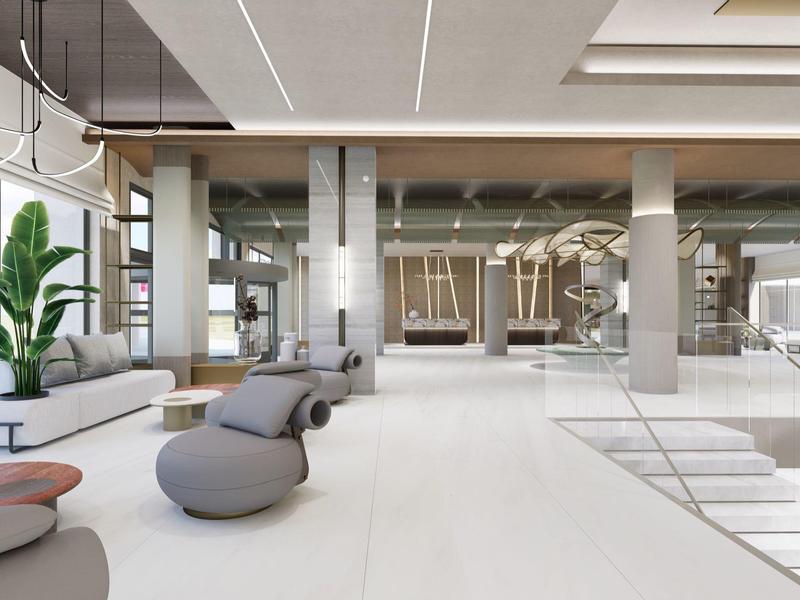 Jasna, nowoczesna strefa lounge hotelu z białymi podłogami i szarymi miejscami do siedzenia.