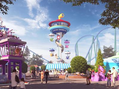 Uitzicht op een pretpark met carrousel en achtbaan onder een blauwe hemel.