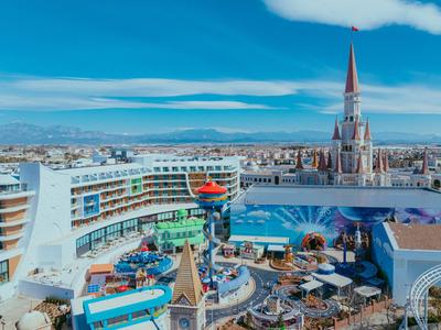 Modern pretpark met carrousel en kerk op de achtergrond bij heldere lucht