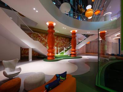 Modern hotelinterieur met oranje zuilen, witte stoelen en een gedraaide podiumpodium.
