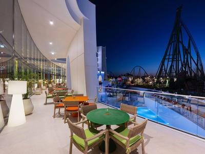 Moderne terras met kleurrijke stoelen met uitzicht op een pretpark 's nachts