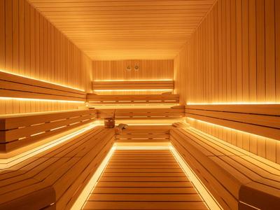 Interieur van een moderne sauna met warme houten vloeren en indirecte verlichting.