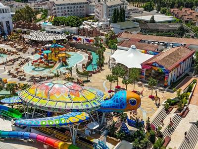 Overzicht van een groot waterpark met kleurrijke glijbanen en zwembaden bij een hotelresort.