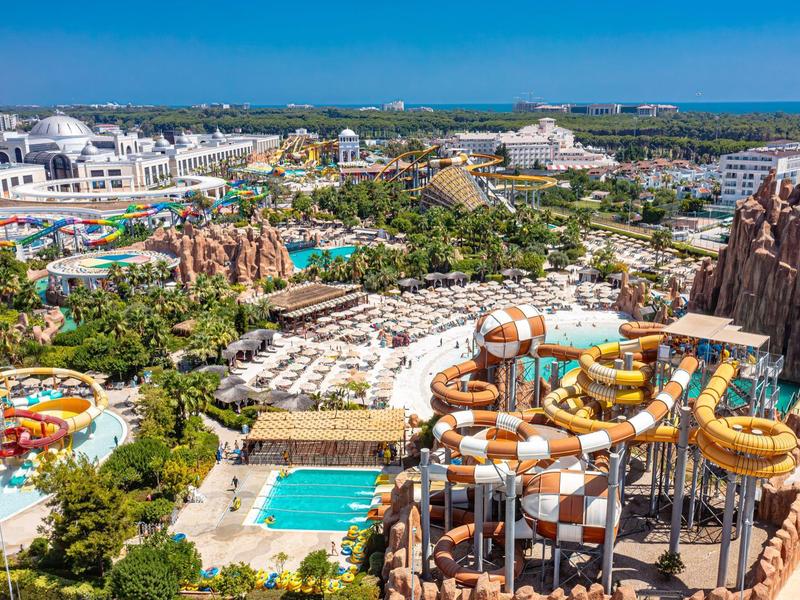 Groot waterpark met meerdere glijbanen en zwembaden in een zonnig vakantiegebied.