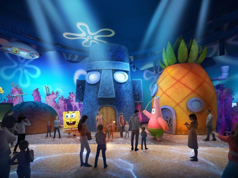 Kleurrijke onderwaterwereld met bekende figuren en grote thematische gebouwen, mensen op de voorgrond.