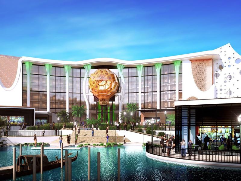 Modern hotelcomplex met zwembad, zithoek en opvallend beeld bij de ingang.