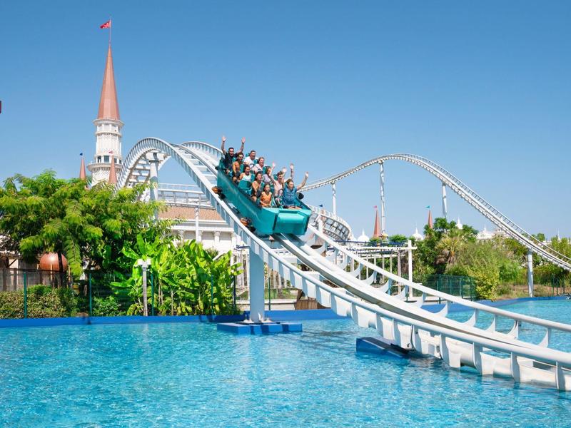 Waterachtbaan in een attractiepark met heldere lucht en mensen in de boot.