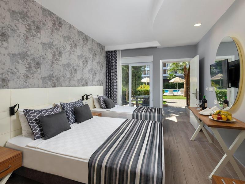 Chambre d'hôtel moderne avec lit double, balcon et décoration sobre.